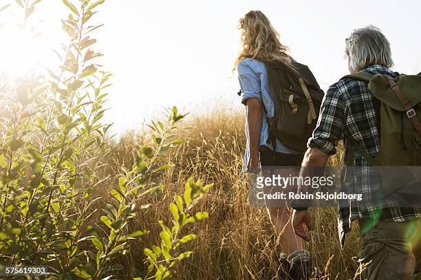 mature man and woman with rucksacks hiking - hiking backpack stock pictures, royalty-free photos & images