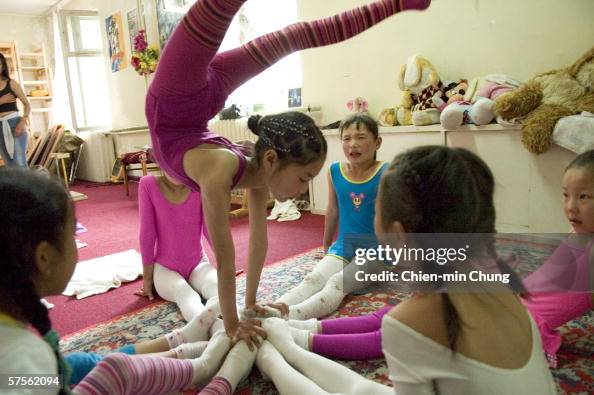 Young girls perform stretching exercises at the contortionist school ...