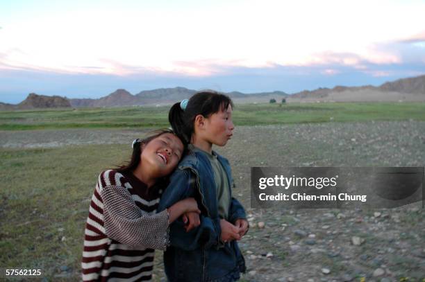 Bolor and one of her twin sisters named Sharaa joke around on July 4, 2005 in Khovd, Mongolia. Balor was adopted into the twins family by her...