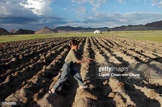 Bolor walking across a neighbors farm in the outskirts of Khovd, Mongolia July 5, 2005.