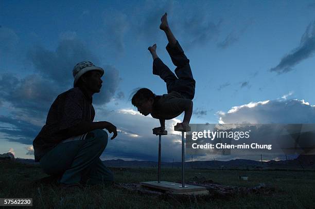 Balor practicing her moves while her father supervises in a field on July 5, 2005 in Khovd, Mongolia.