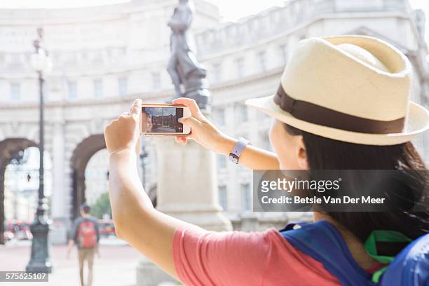 tourists takes photo of city monument - mobile sculpture fotografías e imágenes de stock