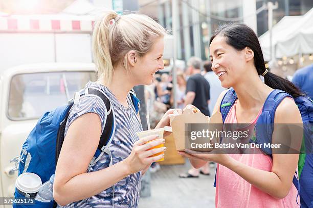 tourists sharing lunch at food market - gedeelde mobiliteit stockfoto's en -beelden