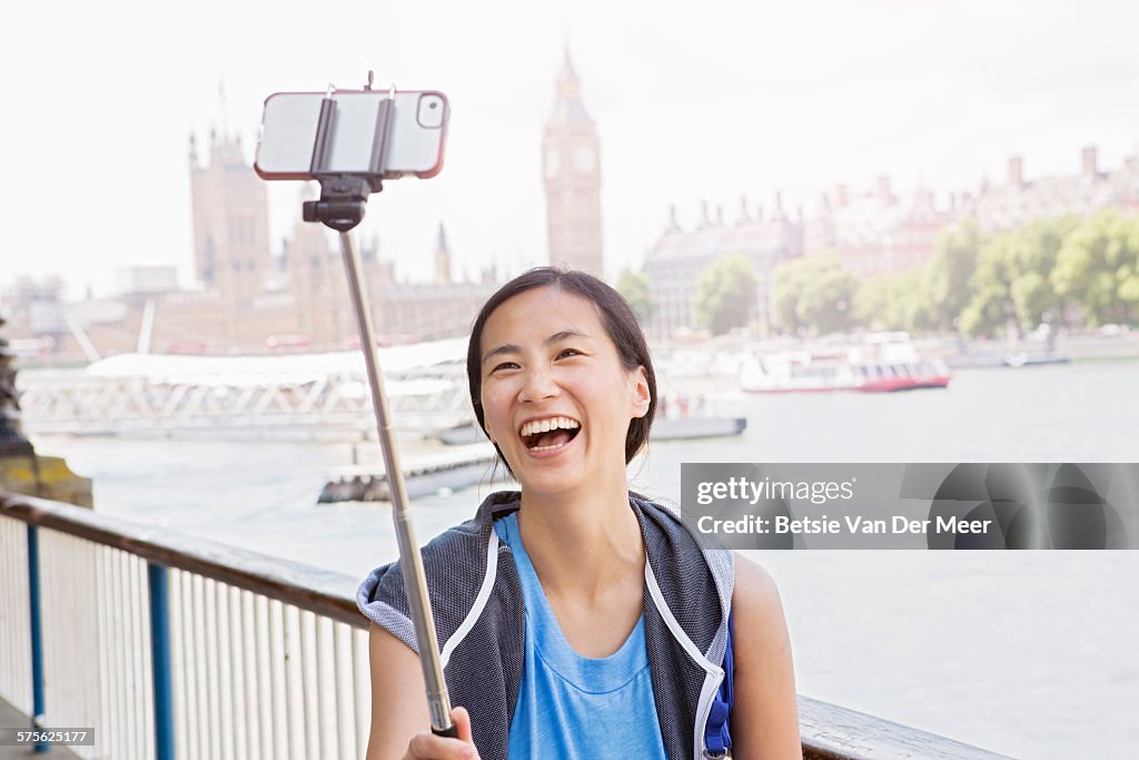 Asian woman takes Selfie near Big Ben and Thames