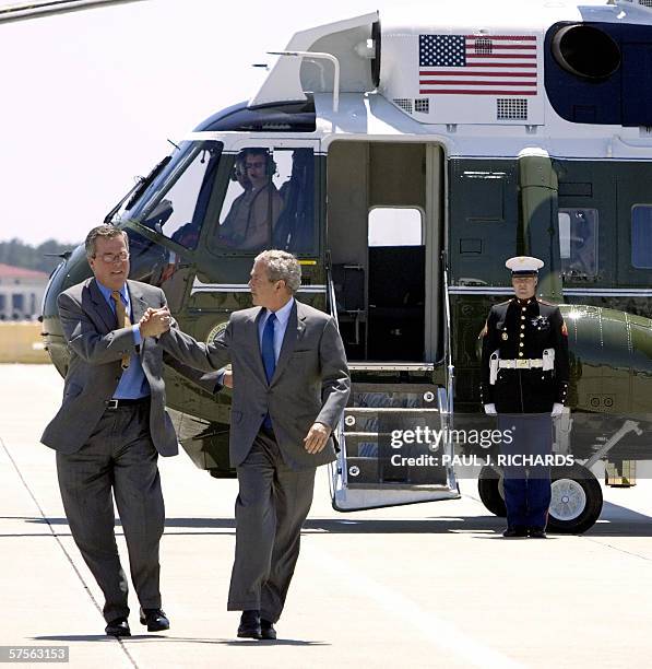 Florida's Governor Jeb Bush shakes hands with his brother President George W. Bush, as they step off Marine One, at MacDill Air Force Base, Florida,...