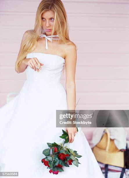 portrait of a bride holding a bouquet of red roses and smoking - nervous bride stock pictures, royalty-free photos & images