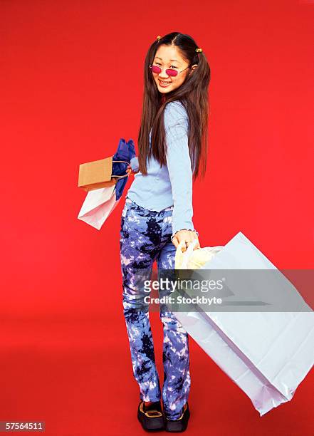 rear view of a teenage girl (16-18) holding shopping bags looking behind her - girls in leggings stock-fotos und bilder
