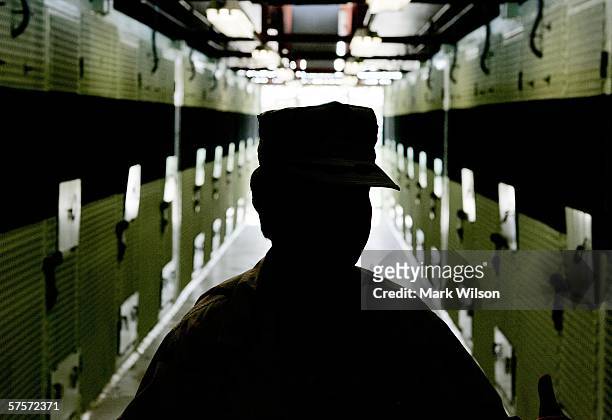 Member of the U.S. Military is silhouetted while standing inside of the cell block inside of Camp 2 at Camp Delta May 9, 2006 in Guantanamo Bay,...