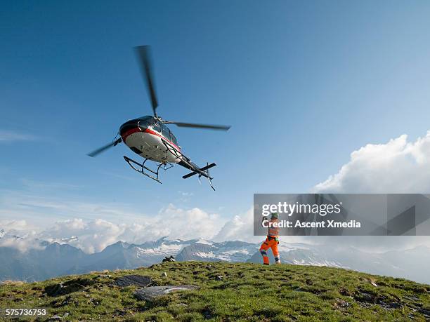 ground crew member takes pic of departing copter - helicóptero fotografías e imágenes de stock