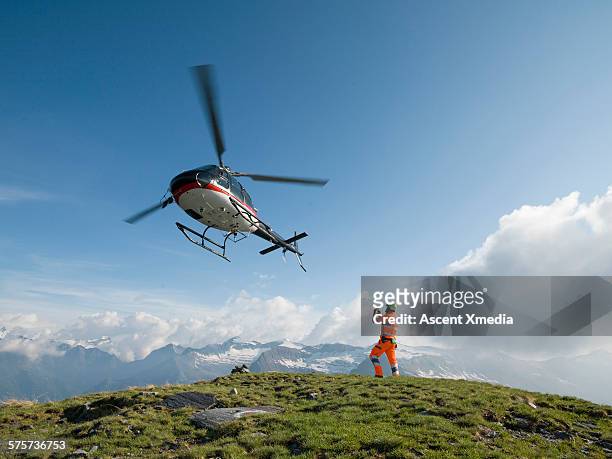 ground crew member takes pic of departing copter - helikopter stockfoto's en -beelden