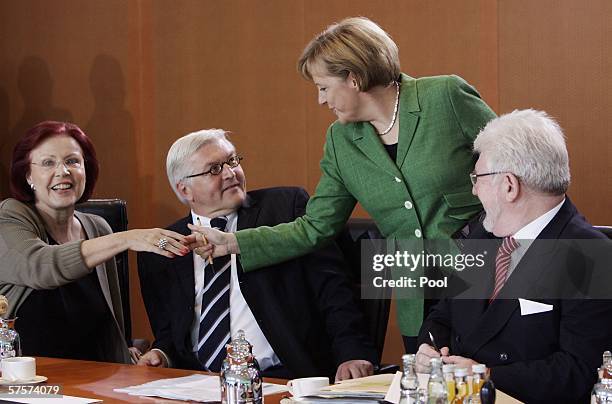 German Chancellor Angela Merkel shakes hands with German Development Minister Heidemarie Wieczorek-Zeul as German Foreign Minister Frank-Walter...