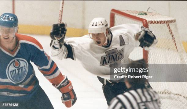 Canadian professional hockey player Wayne Gretzky of the Los Angeles Kings raises his arms and stick as he celebrates a goal scored against his old...