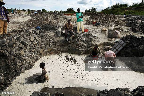 Young boys look for copper standing in a pit on December 13, 2005 in Ruashi mine about 20 kilometers outside Lubumbashi, Congo, DRC. They are some of...