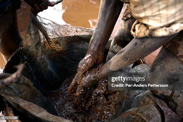 An unidentified young man cleans bags of cobalt that's been taken out of a cobalt mine on December 13, 2005 in Ruashi mine about 20 kilometers...