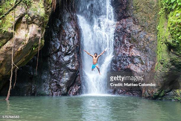local man jumping off a waterfall, kadavu, fiji - catarata fotografías e imágenes de stock