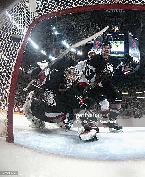 Goalie Ryan Miller and Teppo Numminen of the Buffalo Sabres watch a shot by Jason Spezza of the Ottawa Senators score past them in game three of the...
