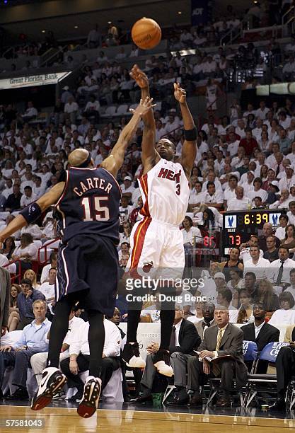Dwyane Wade of the Miami Heat takes a three-point shot against Vince Carter of the New Jersey Nets in game two of the Eastern Conference Semifinals...