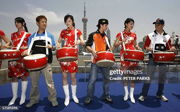 MotoGP riders Casey Stoner of Australia , Makoto Tamada of Japan and 250cc World Champion Andrea Dovizioso of Italy plays drums with promotion girls...