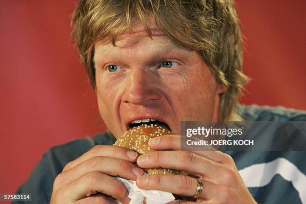 German national team's number two goalkeeper Oliver Kahn bites into a burger during an advertising-campaign in Munich, 11 May 2006. Kahn promotes a...