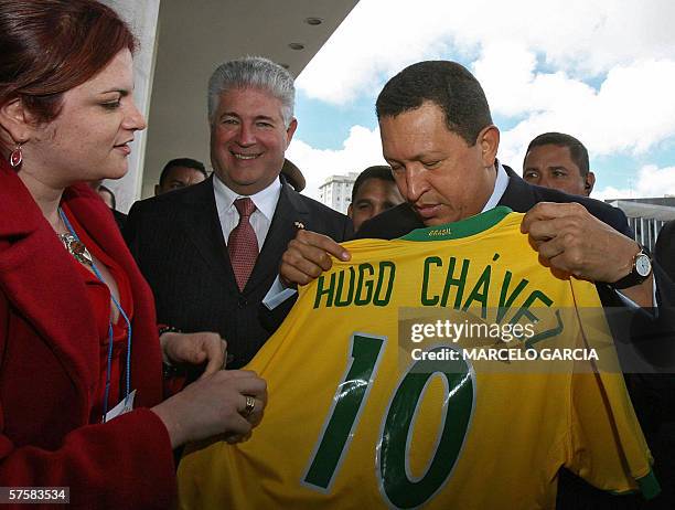 El presidente de Venezuela Hugo Chavez recibe una camiseta del seleccionado de futbol de Brasil con su nombre, acompanado por el gobernador del...