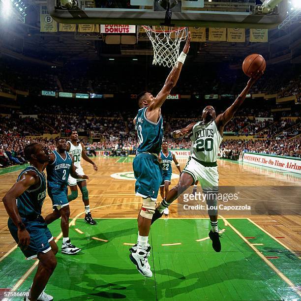 Sherman Douglas of the Boston Celtics shoots a layup against Alonzo Mourning of the Charlotte Hornets during a game at the Boston Garden on November...