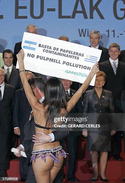 Greenpeace demonstrator wearing a bikini is dragged away by security as she shows a banner against pulp mill plants installation in Fray Bentos,...