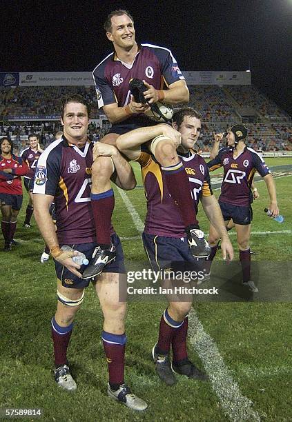 Mark Conners of the Reds is chaired off the ground by team-mates James Horvill and Steven Moore after the round fourteen Super 14 match between the...