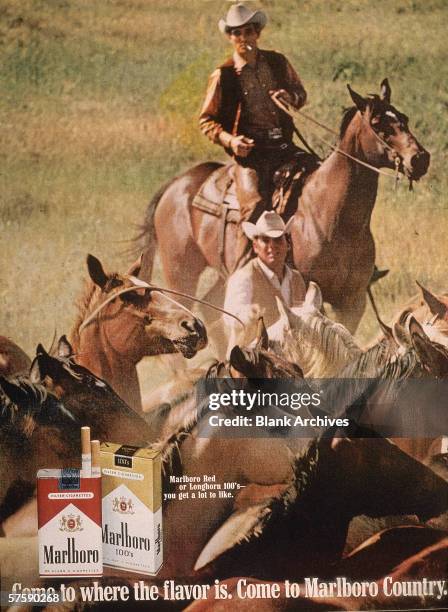 Image of two 'Marlboro Man' cowboys herding horses in a magazine ad for Marlboro cigarettes, 1970s.