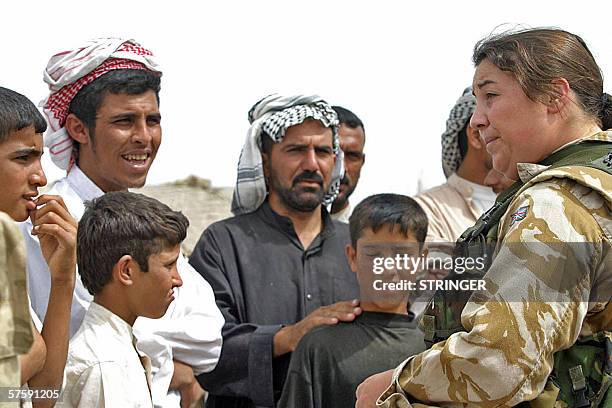 British soldier talks to Iraqis in the city of Nasiriyah, southeast of Baghdad 12 May 2006. British, Romanian and Italian soldiers conducted a joint...