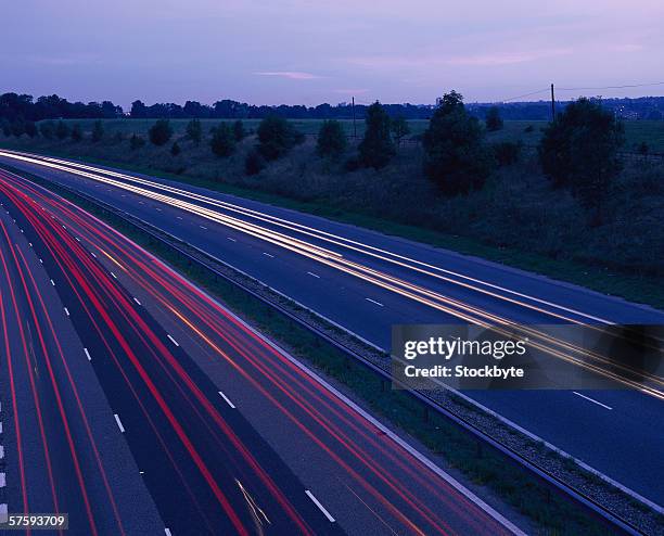 time lapse view of traffic on a street at twilight - traffic time lapse stock pictures, royalty-free photos & images