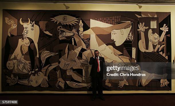 Member of the security detail for John Bolton, the United States Ambassador to the United Nations, speaks on his radio in front of a reproduction of...