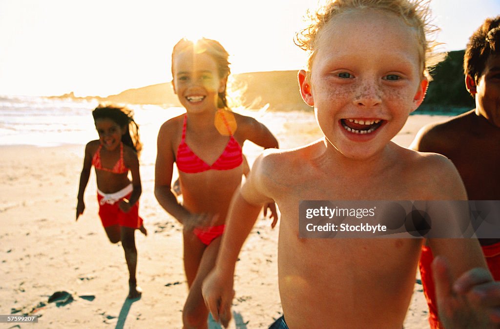 Portrait of a group of children running on the beach