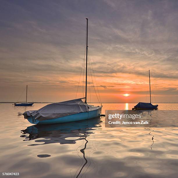 sailing vessels at sunset - jenco van zalk stock pictures, royalty-free photos & images