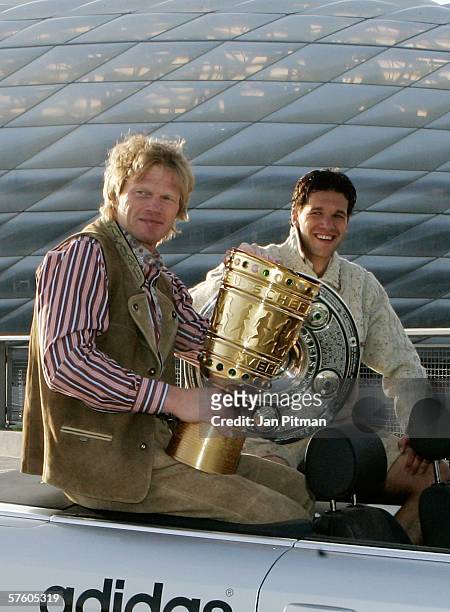 Oliver Kahn and Michael Ballack of Bayern Munich raise the championship trophy and the German football cup during a car convoy on May 13, 2006 in...