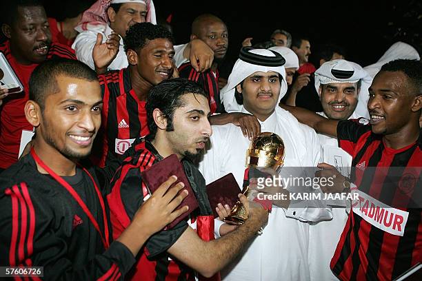 Sheikh Abdullah bin Hamad al-Thani , the head of Al-Rayyan club, holds the trophy of Qatar's Emir Cup soccer tournament after his team beat...