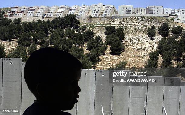 Palestinian boy is seen standing on the balcony of his home 09 May 2006 in the Shufat refugee camp, separated by the controversial Israeli separation...