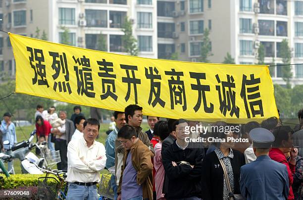 Owners hang a banner that reads: "Strongly condemn the dishonest real estate developer" to protest at the Shanghai Cannes Residential Area May 14,...