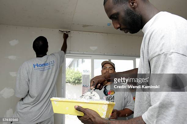 Tim Thomas of the Phoenix Suns helps spackle the living room of Maritza Jacobo's new home May 13, 2006 in Torrance, California. NBA Cares and Home...