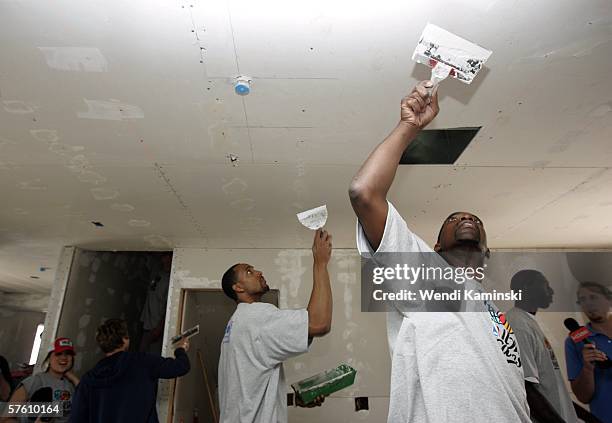 Former Los Angeles Lakers player AC Green and Tim Thomas of the Phoenix Suns work on Habitat for Humanity's housing project for Maritza Jacobo's new...