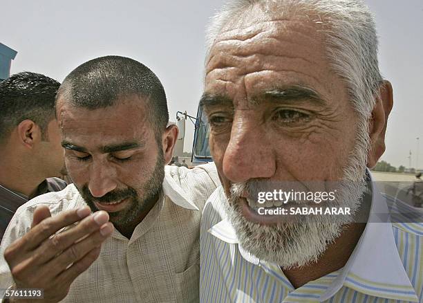 Freed prisoner comforts his colleague upon their release in central Baghdad 15 May 2006. More than 100 Iraqi prisoners were freed from the notorious...