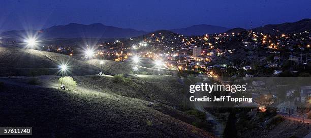 Border Patrol search lights glow from the hillside in the direction of Nogales, Sonora, Mexico where a wall separates the two cities along the U.S....