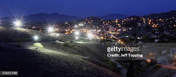 Border Patrol search lights glow from the hillside in the direction of Nogales, Sonora, Mexico where a wall separates the two cities along the U.S....