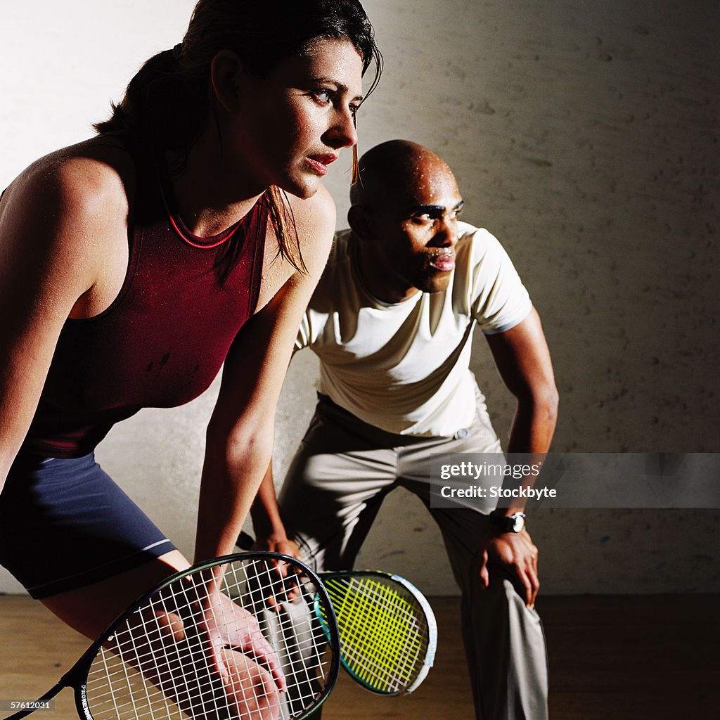 Side profile of a young couple playing squash