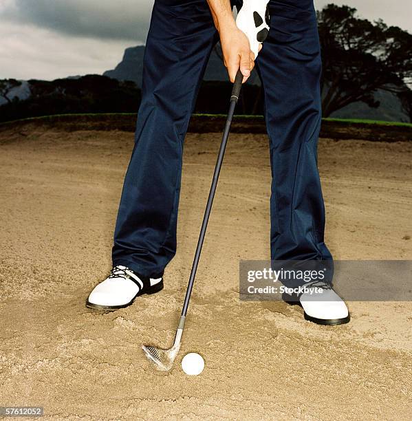 person playing golf in the sand pit - adult ball pit stock-fotos und bilder