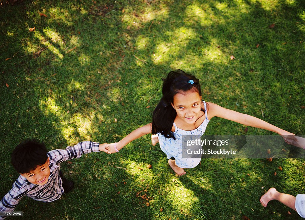 Elevated view of children (4-8) walking in a circle in a yard