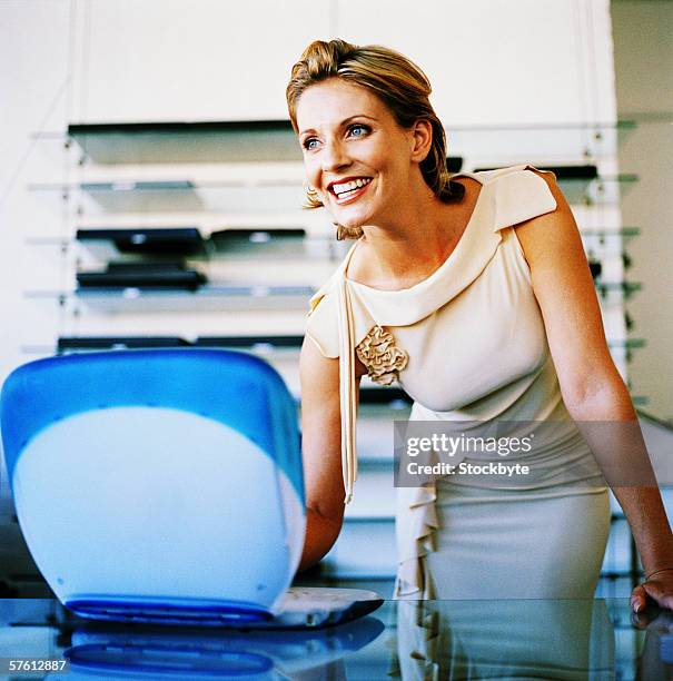 close-up of a young woman bending forward over a laptop - bending over in skirt stock-fotos und bilder