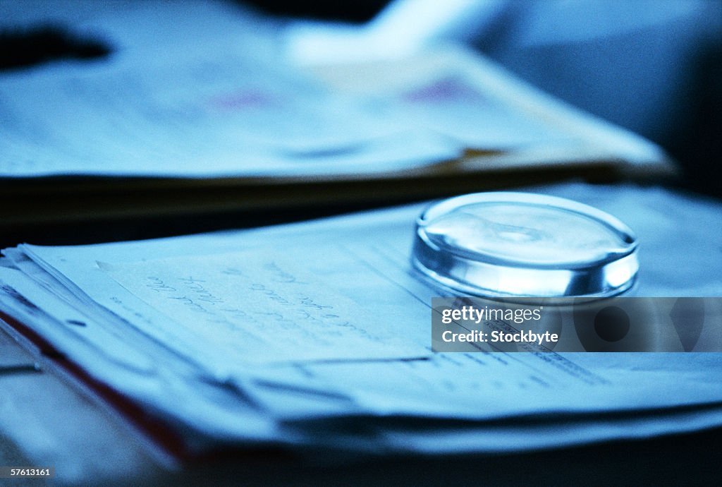 A glass paper weight on sheets of papers (tungsten)