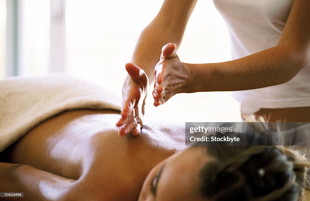 Young woman receiving a back massage from a masseuse