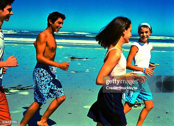 group of teenagers (14-18) smiling running at the beach - 15 years girl bare stock pictures, royalty-free photos & images