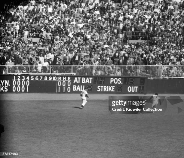 Outfielder Mickey Mantle, of the New York Yankees, runs down the deep flyball hit by Gil Hodges, of the Brooklyn Dodgers, during the fifth inning of...